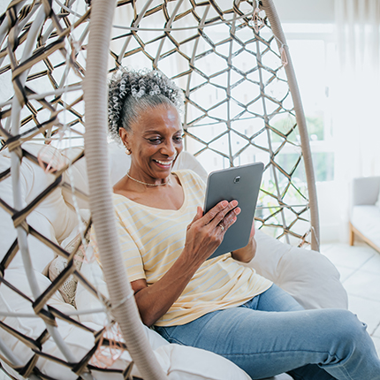 A woman enjoying her online banking account while sitting in a hanging bench
