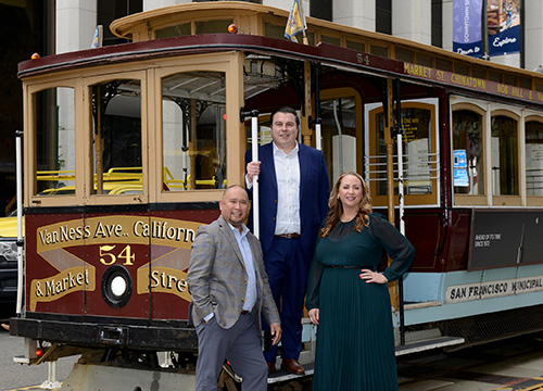 Our team smiling and standing in front of a train.